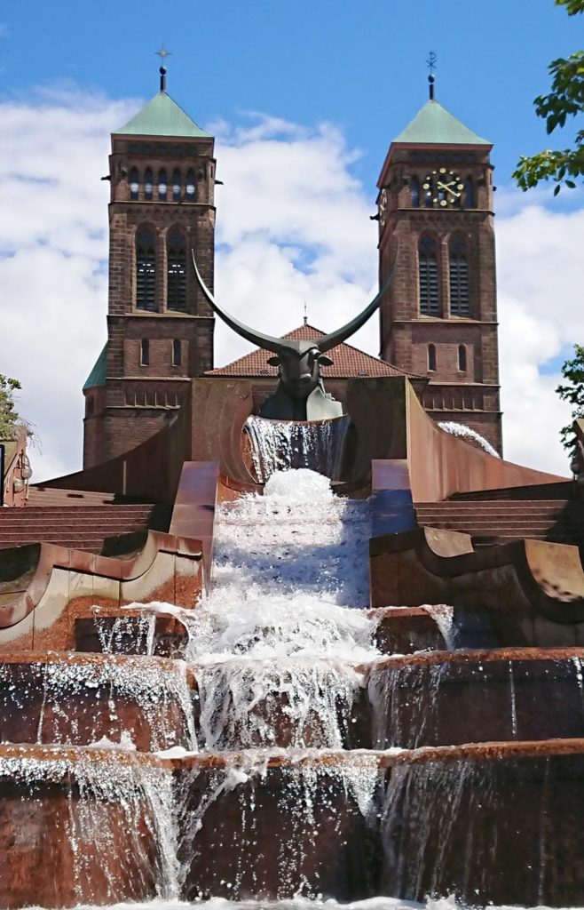 Die Schlosstreppenanlage mit Stierskulptur und Wasserfall vor der Kirche Sankt Pirminius in Pirmasens