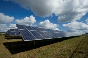 Große Solarpanels auf einem Feld unter blauem Himmel mit Wolken