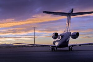 Heckansicht eines Privatjets auf dem Rollfeld bei Sonnenuntergang